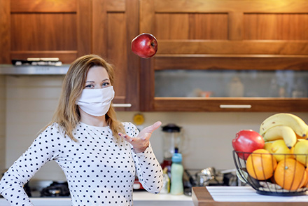 In fear of infection from Coronavirus COVID-19 Pandemic, man in a mask and protective gear eats a cutlet.